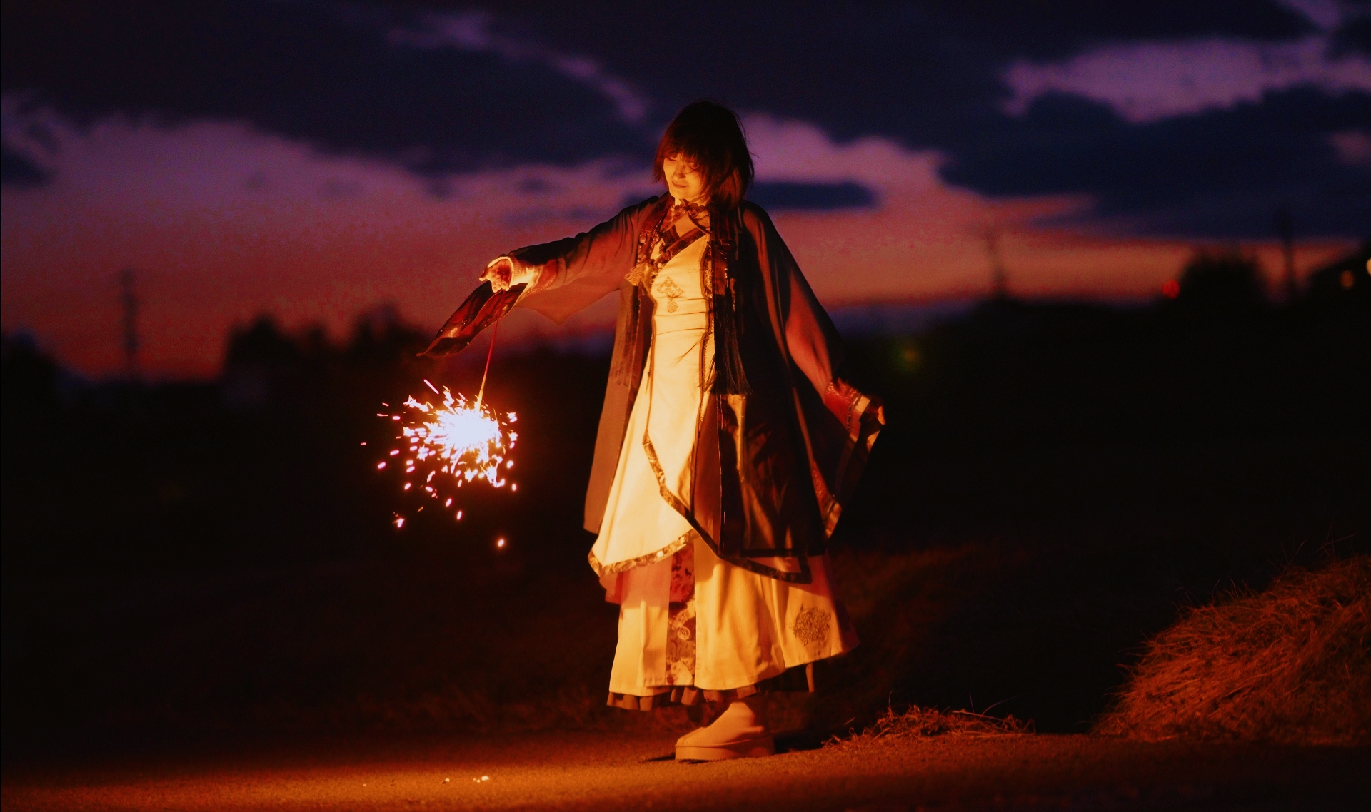 SUMI in the KOURO music video holding a firework at dusk